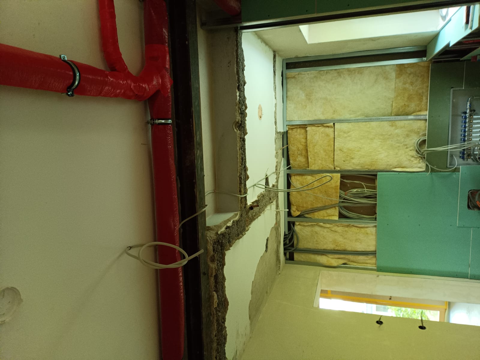 Installationswand mit Metallprofilen, Leitungen und Dämmung
