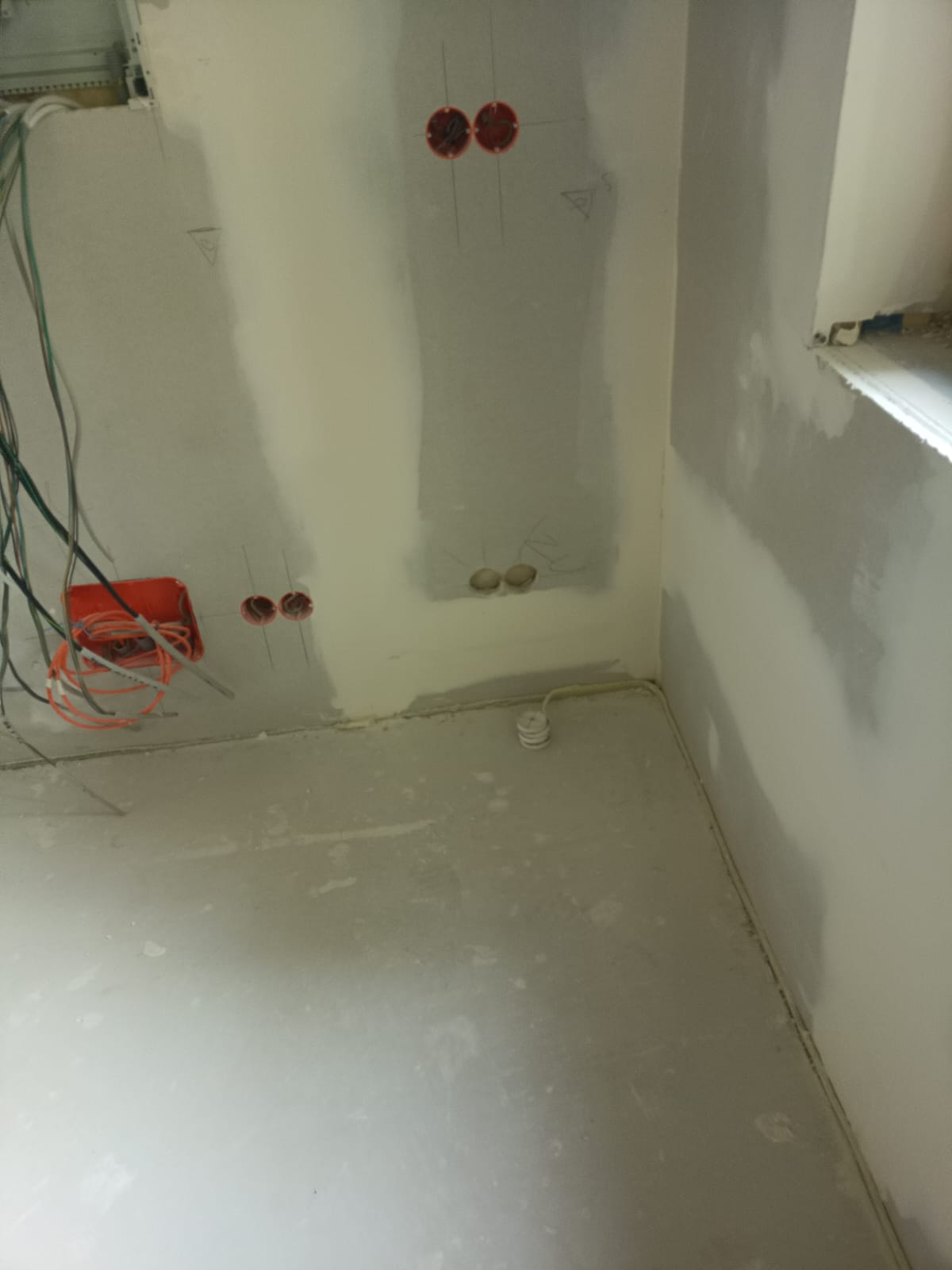 Verspachtelte Installationswand mit vorbereiteten Elektroanschlüssen