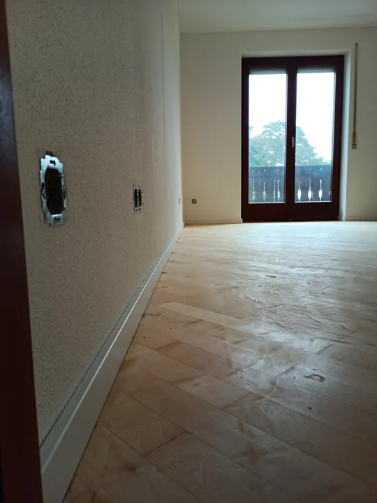 Schmaler heller Durchgang mit Parkett und Blick zur Balkontür