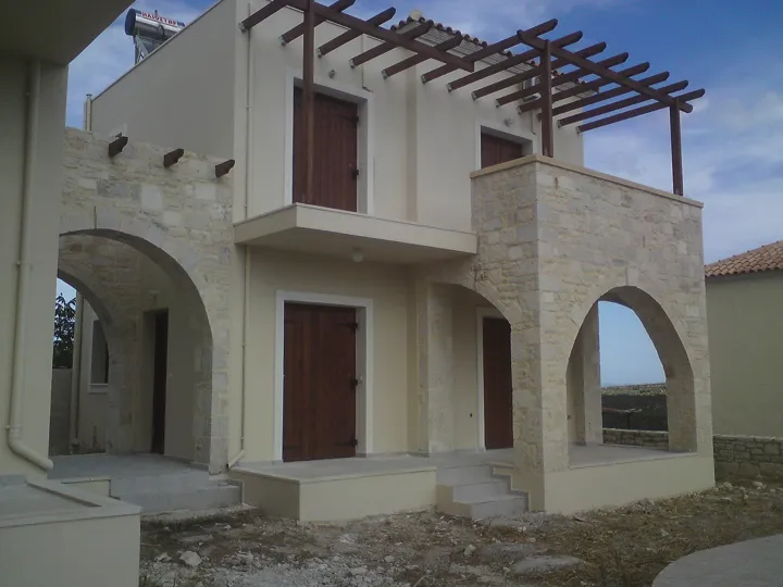 Mediterranes Haus mit heller Fassade, Natursteinbögen und hölzerner Pergola