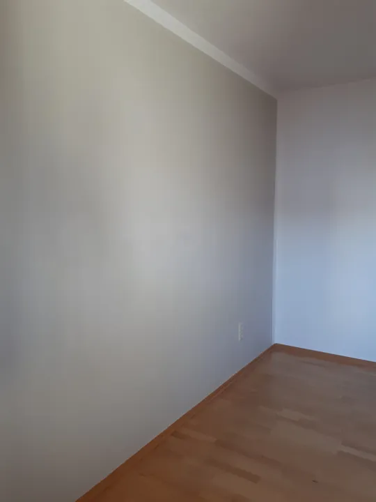 Glatte helle Wände in einer Raumecke über einem Holzboden