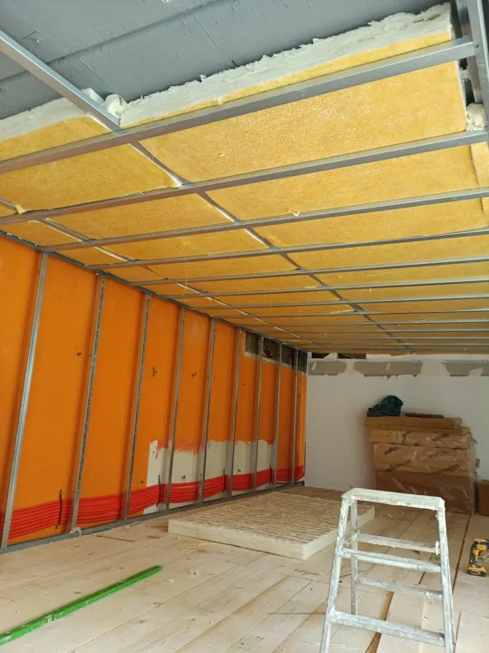 Metallunterkonstruktion vor orangefarbenen Wänden und an der Decke