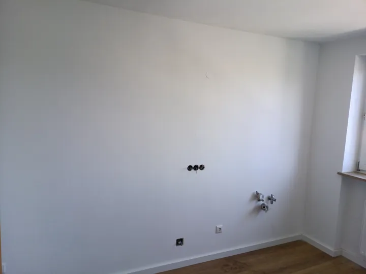 Weiß gestrichene Wand mit vorbereiteten Steckdosenöffnungen